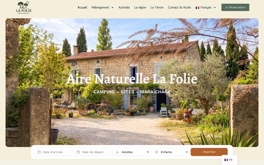 Accueil du site de l’Aire Naturelle La Folie : photo d’un mas en pierre et de son jardin, titre « Aire Naturelle La Folie », barre de recherche avec dates, adultes et enfants