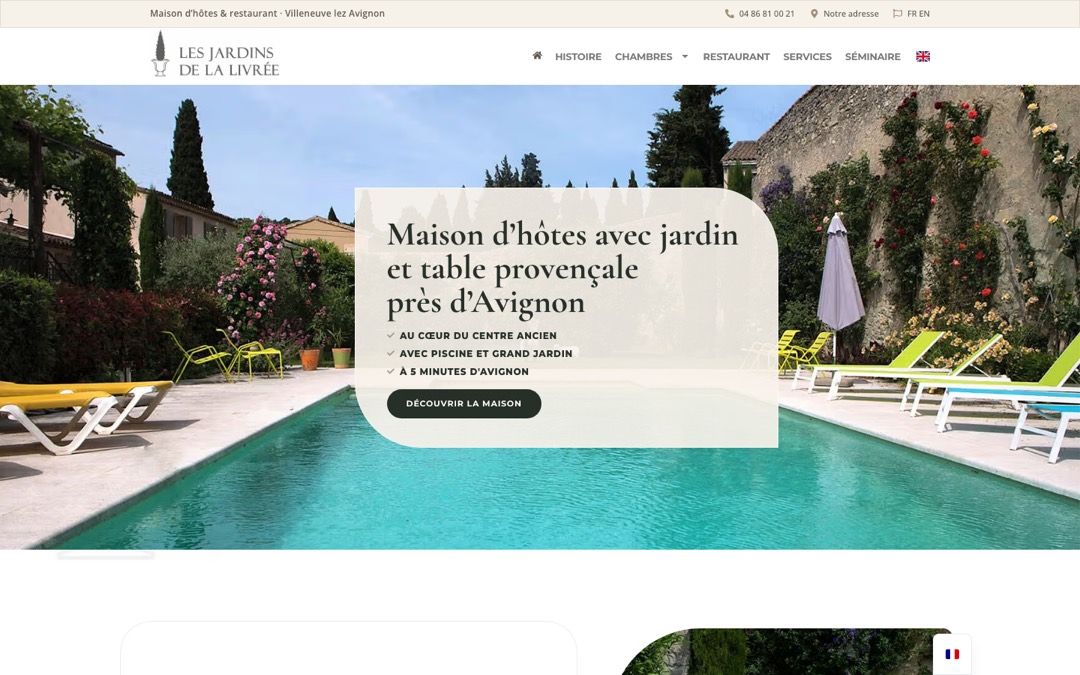 Accueil du site des Jardins de la Livrée : photo d’une piscine bordée de transats et d’un mur de pierre fleuri, carte blanche avec le titre « Maison d’hôtes avec jardin et table provençale près d’Avignon »