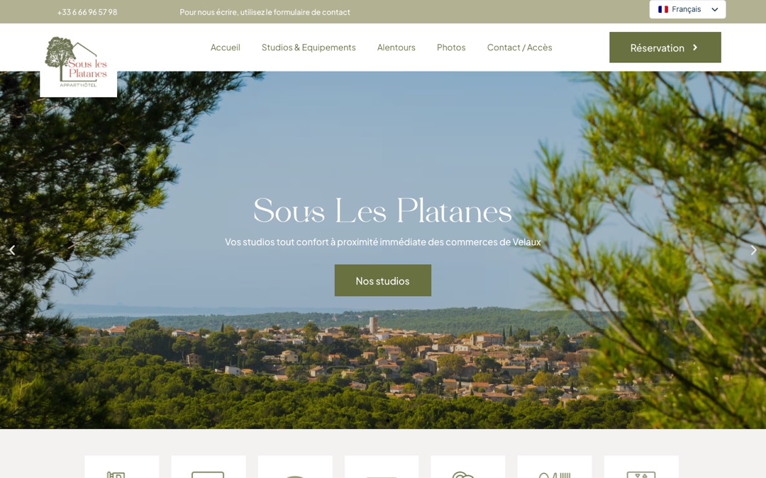 Accueil du site de l’appart’hôtel Sous Les Platanes, à Velaux : photo du village entouré de pins, titre de l’établissement et bouton « Réservation » en haut à droite