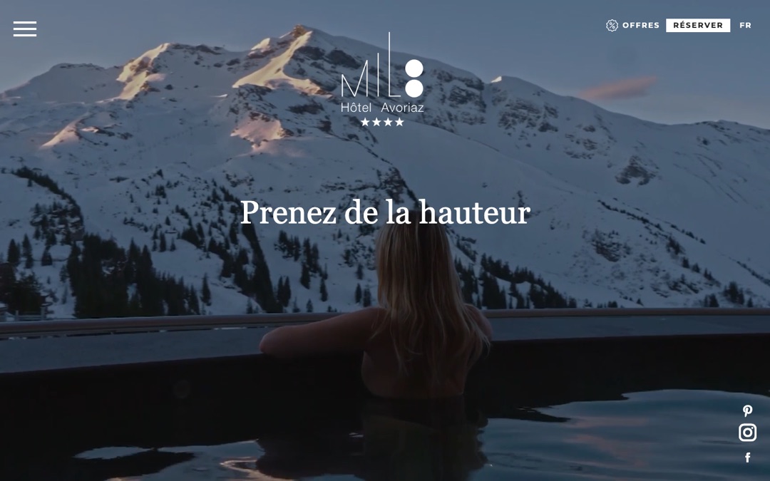 Accueil du site du MiL8 : photo d’une personne dans l’eau face aux sommets enneigés, texte « Prenez de la hauteur » et logo de l’hôtel quatre étoiles