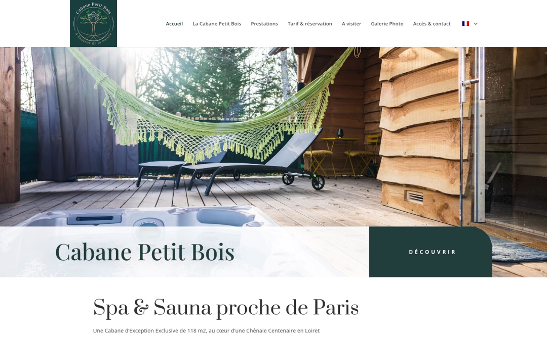 Accueil du site de la Cabane Petit Bois : terrasse en bois avec hamac vert, deux transats et spa, sous le titre « Cabane Petit Bois » et un bouton « Découvrir »