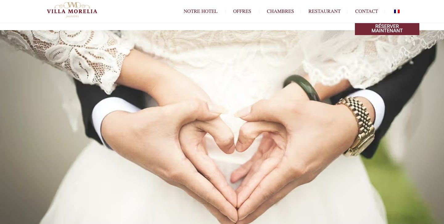 Page Mariage du site de la Villa Morelia, à Jausiers : deux mains en forme de cœur sur une robe de mariée