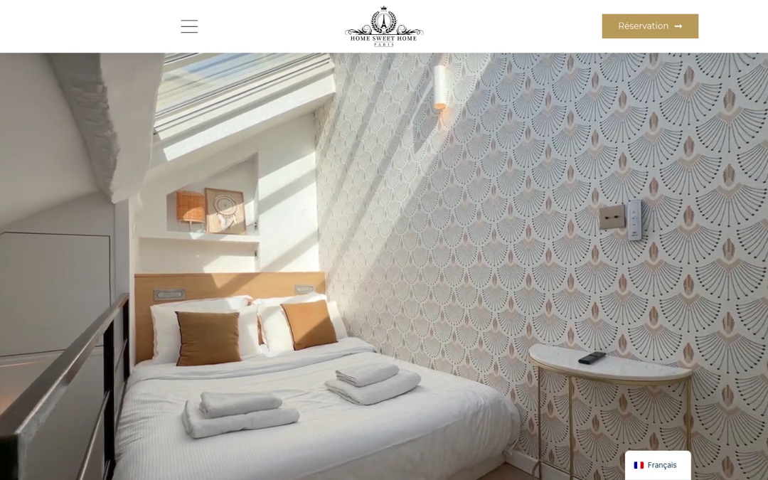 Accueil du site de Home Sweet Home Paris : chambre sous verrière en haut de page, logo au centre, menu à gauche et bouton « Réservation » à droite
