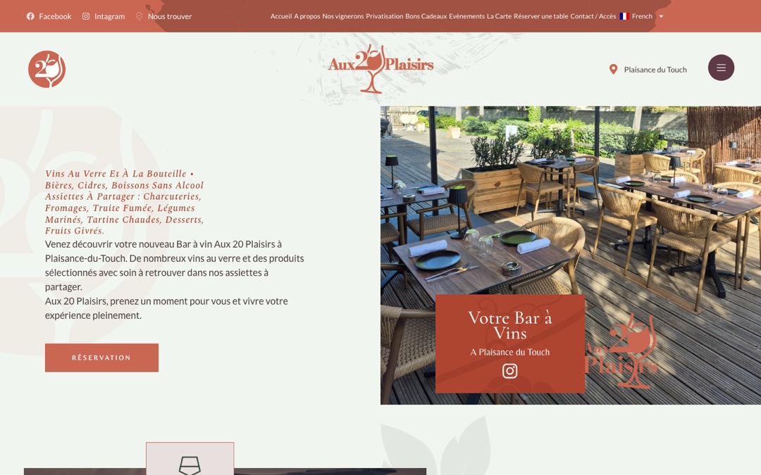 Accueil du site Aux 20 Plaisirs, bar à vins à Plaisance-du-Touch : terrasse en bois avec tables dressées, logo en forme de verre et bouton « Réservation »