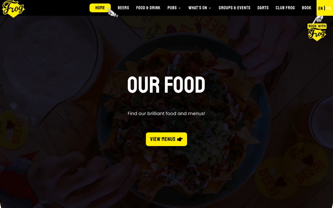 Accueil du site FrogPubs : menu jaune et noir (Beers, Food & Drink, Pubs, Darts, Book), carrousel « Our food » et bouton « Book with Frog » en haut à droite