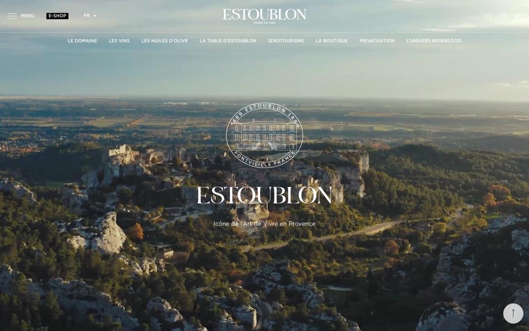 Accueil du site du Château d’Estoublon : vue aérienne du domaine et de ses collines, logo du domaine et titre « Estoublon, icône de l’Art de Vivre en Provence »