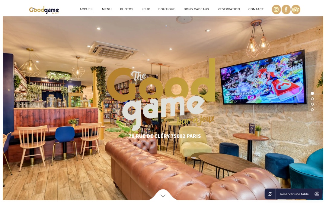 Accueil du site The Good Game : salle du bar à jeux avec canapé en cuir, étagères de jeux de société, logo jaune et bouton « Réserver une table » en bas à droite