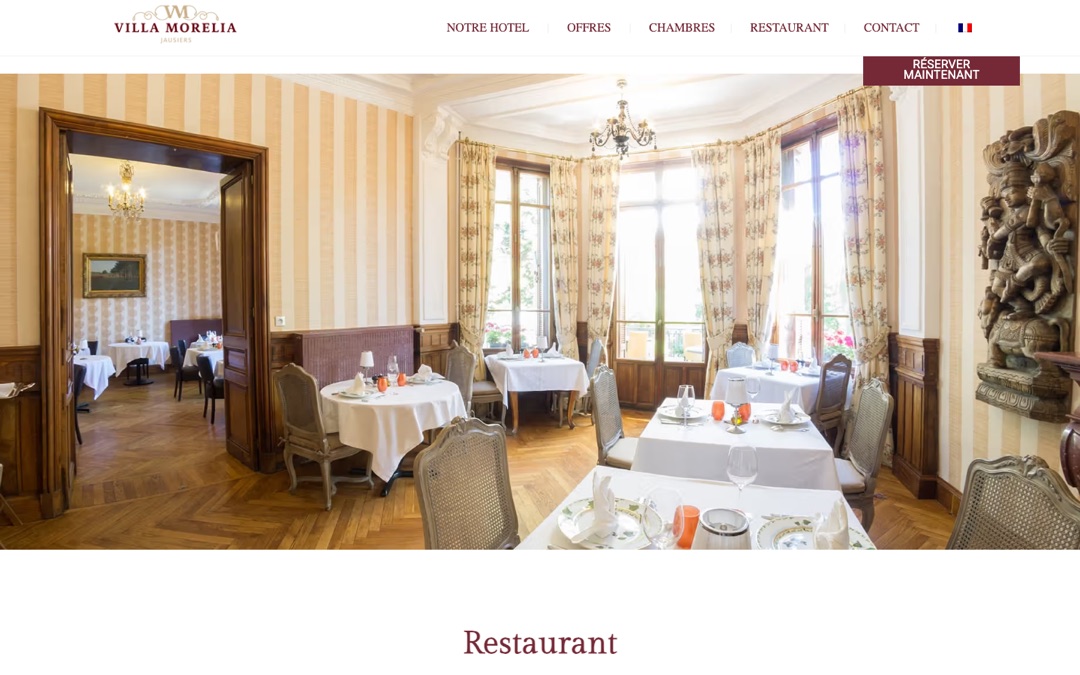 Page « Restaurant » du site de la Villa Morelia : salle à manger aux nappes blanches et aux grandes fenêtres, menu en haut de page et bouton « Réserver maintenant »