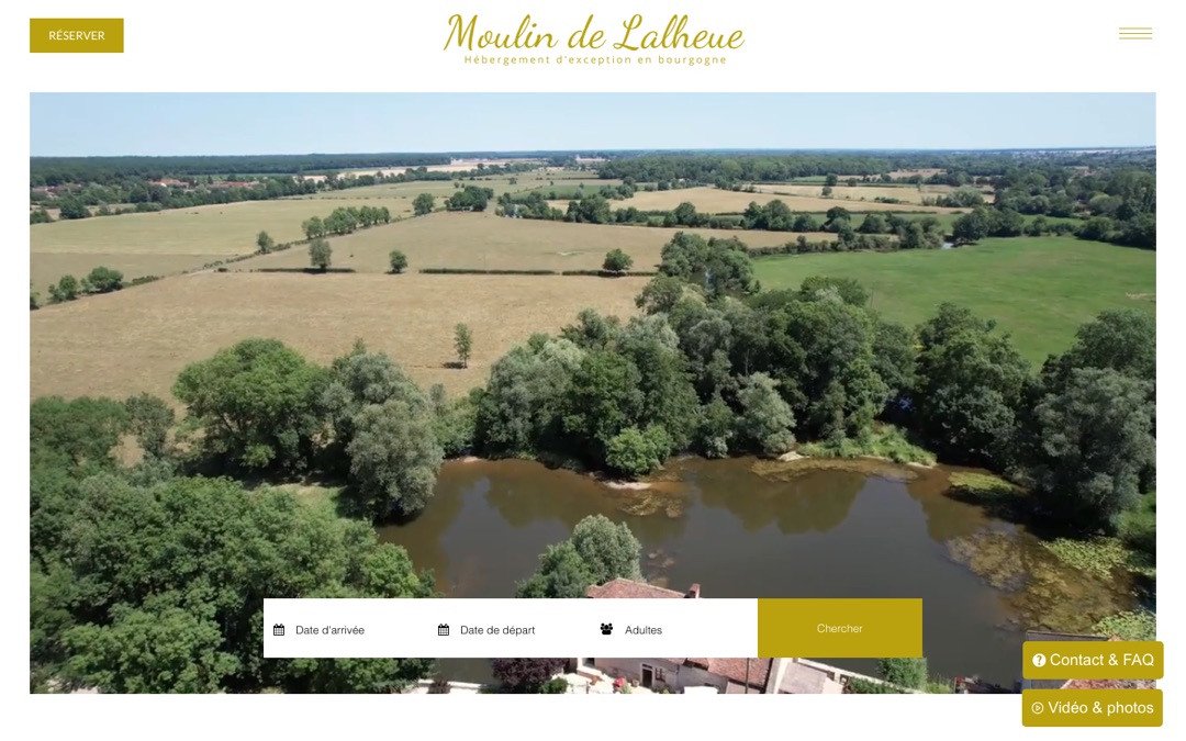 Accueil du site du Moulin de Lalheue : vue aérienne d’un moulin au bord d’un étang entouré de prés, barre Date d’arrivée, Date de départ, Adultes et bouton Réserver en haut à gauche