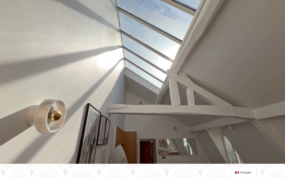 Accueil du site de Home Sweet Home Paris : vidéo plein écran d’un appartement sous les toits, avec une verrière, et sélecteur de langue en bas à droite