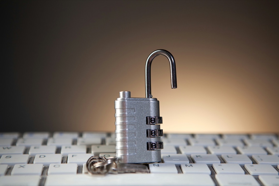 Cadenas à code ouvert posé sur un clavier d’ordinateur