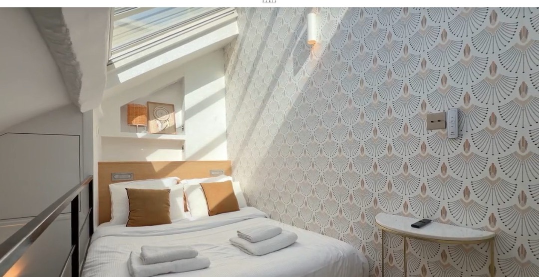 Accueil du site Home Sweet Home, à Paris : une chambre mansardée en plein cadre, le logo au centre de l’en-tête et le bouton « Réservation » à droite