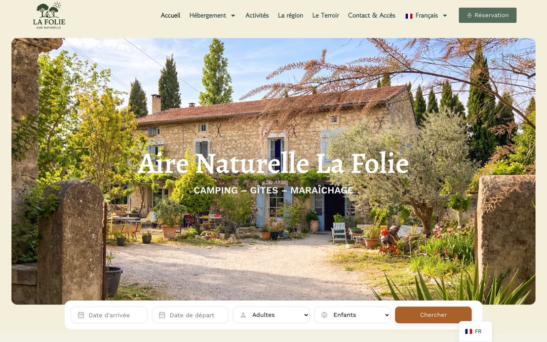 Accueil du site d’Aire Naturelle La Folie : mas en pierre en photo d’accueil, barre de réservation (arrivée, départ, adultes, enfants, bouton « Chercher ») et bouton « Réservation » dans le menu