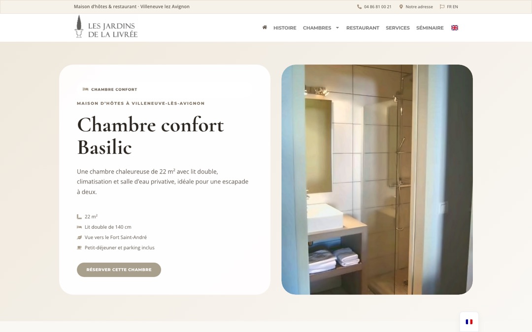 Page de la chambre confort Basilic du site des Jardins de la Livrée : titre, description de 22 m² avec lit double, climatisation et salle d’eau privative, liste des équipements, bouton « Réserver cette chambre » et photo de la salle d’eau