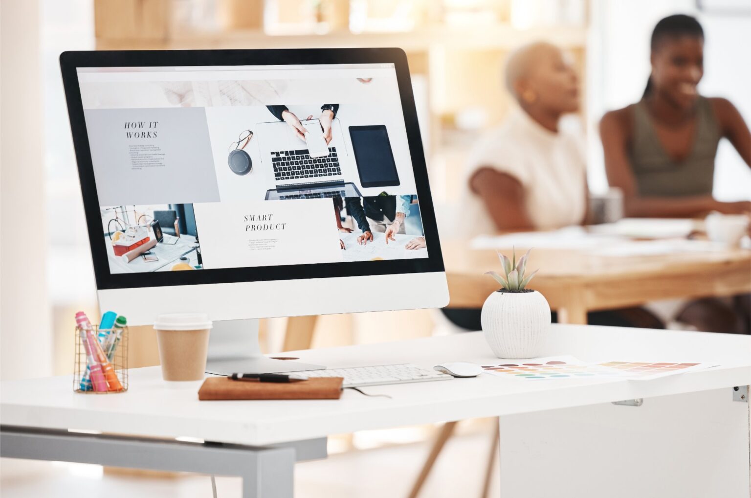 Écran d’ordinateur affichant la maquette d’un site, dans un bureau lumineux