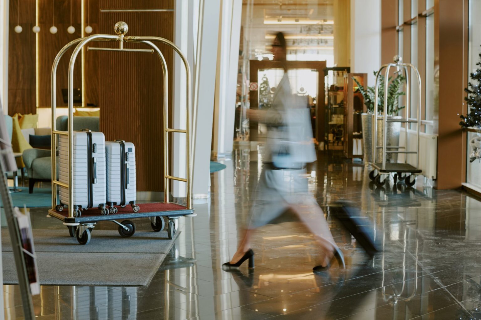 Hall d’hôtel lumineux, un voyageur traverse la réception