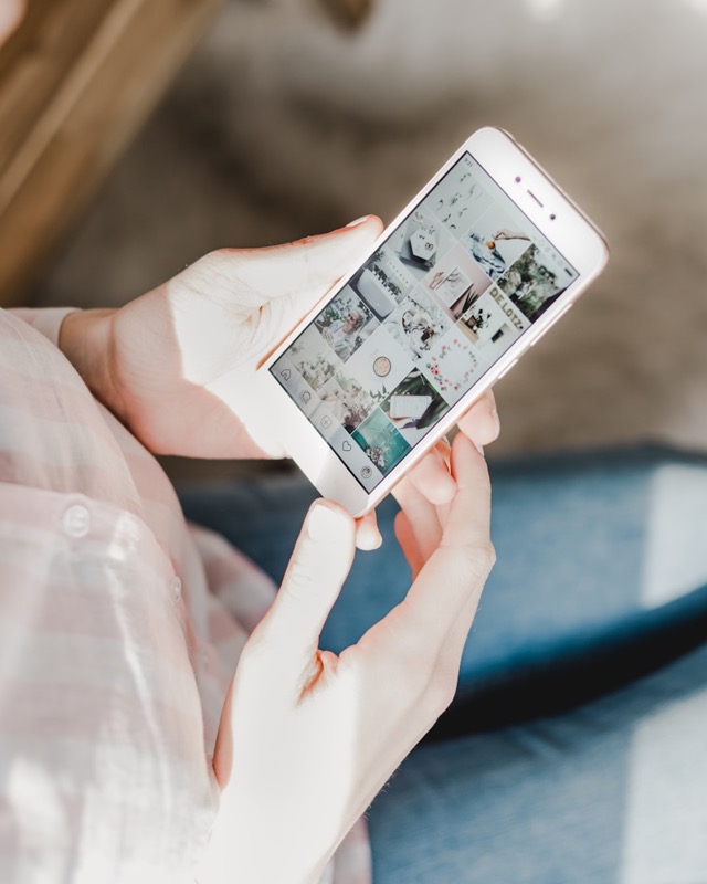 Une personne fait défiler sur son téléphone une grille de photos