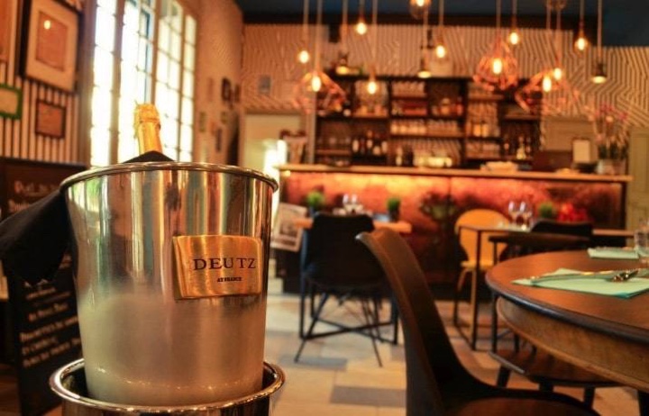 Seau à champagne posé sur une table, avec le bar d’un restaurant en arrière-plan
