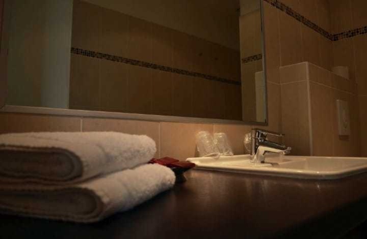 Salle de bains avec des serviettes blanches pliées près d’un lavabo